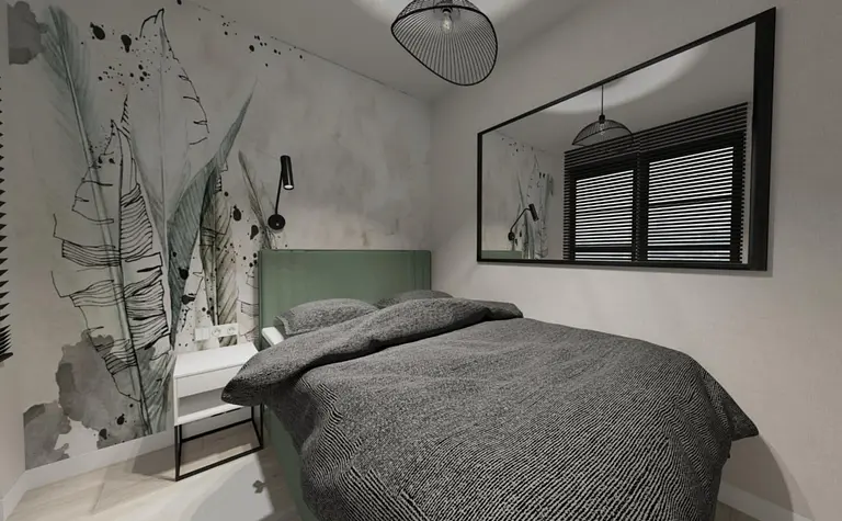 Wnętrze sypialni z szaro-białym łóżkiem, zielonym wezgłowiem oraz industrialnymi lampami.
