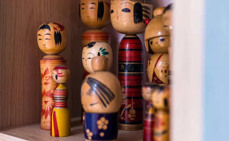 Drewniana półka z kolekcją figurek w stylu dopamine decor i vintage.