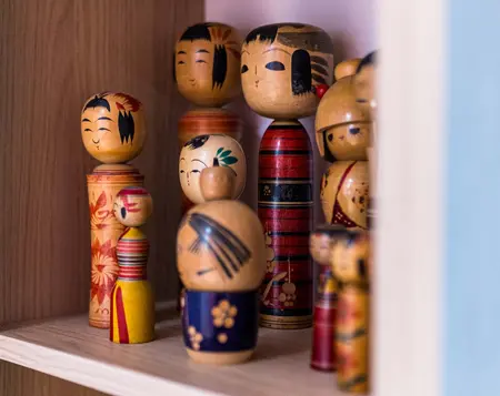 Drewniana półka z kolekcją figurek w stylu dopamine decor i vintage.