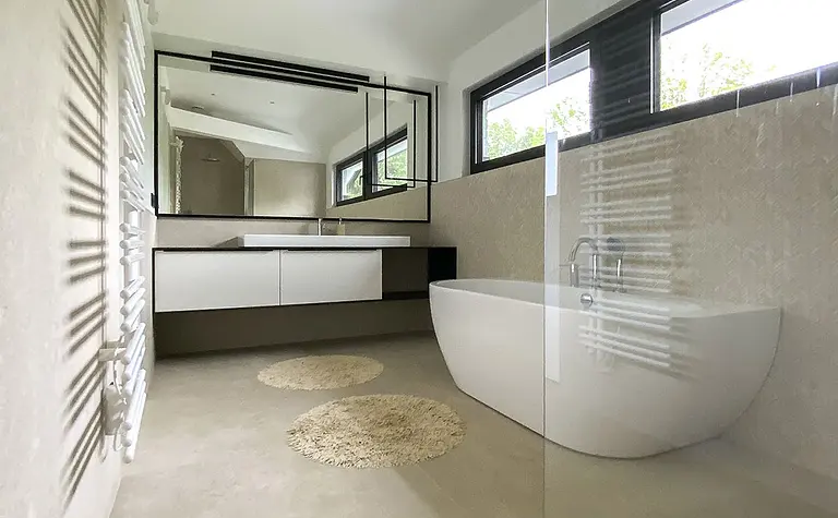 Minimalistyczna łazienka z wanną, lustrem i jasnym wykończeniem, styl minimaluxe, quiet luxury.
