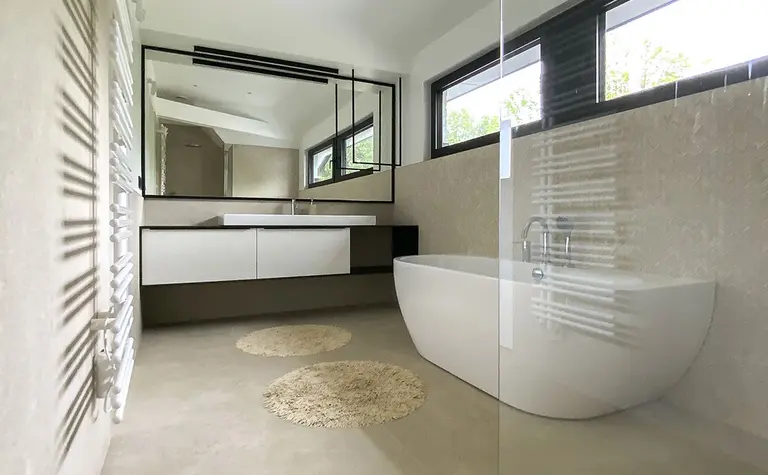 Minimalistyczna łazienka z wanną, lustrem i jasnym wykończeniem, styl minimaluxe, quiet luxury.
