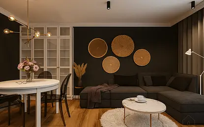Wnętrze salonu z szarym narożnikiem, białym stołem oraz dekoracjami w stylu glamour i minimalistycznym.