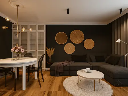 Wnętrze salonu z szarym narożnikiem, białym stołem oraz dekoracjami w stylu glamour i minimalistycznym.