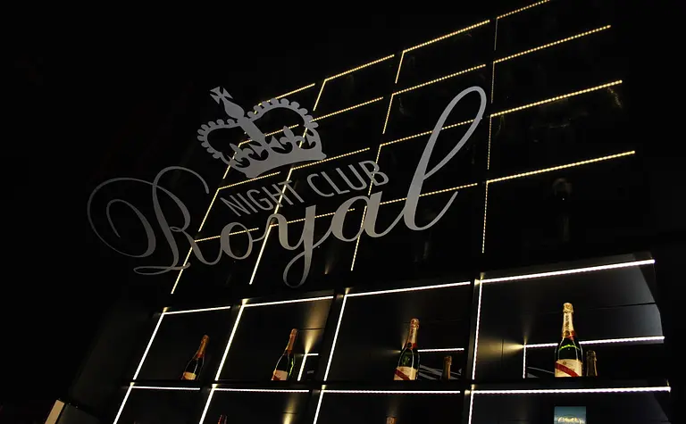 Wnętrze klubu nocnego z podświetlaną półką na szampana, styl glamour i nowoczesny.