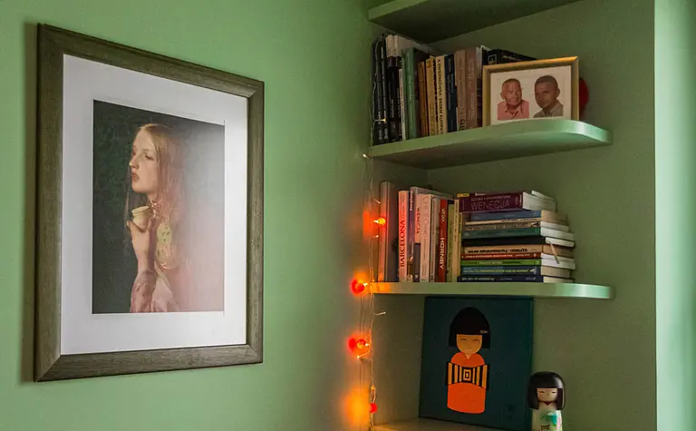 Wnętrze z zieloną ścianą, półkami na książki, vintage i dopamine decor.