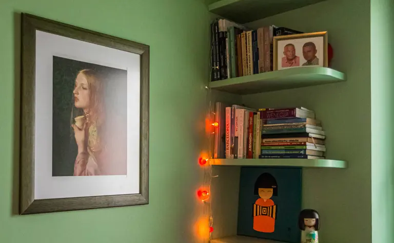 Wnętrze z zieloną ścianą, półkami na książki, vintage i dopamine decor.