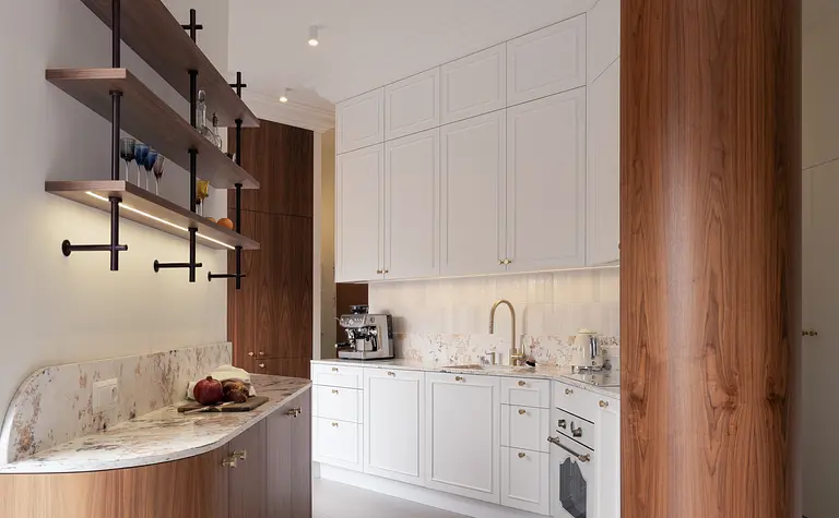 Kuchnia w stylu eklektycznym i vintage z białymi meblami i drewnianymi akcentami.