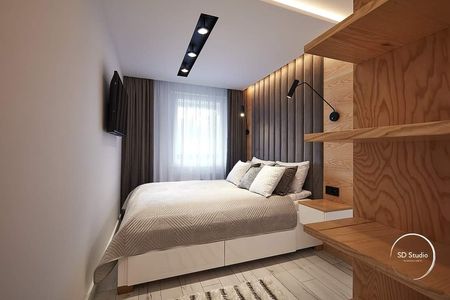 Sypialnia w stylu nowoczesnym i skandynawskim z białym łóżkiem i drewnianymi detalami.