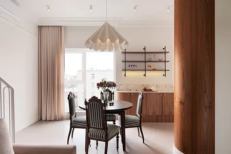 Wnętrze jadalni w stylu eklektycznym i vintage z drewnianym stołem i roślinami.