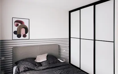 Minimalistyczna sypialnia z szarym łóżkiem i białą szafą, harmonijna przestrzeń