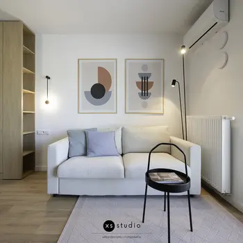 Wnętrze salonu w stylu skandynawskim z jasną sofą i drewnianymi detalami.