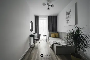 Wnętrze pokoju w stylu japandi z minimalistycznym narożnikiem i rośliną.