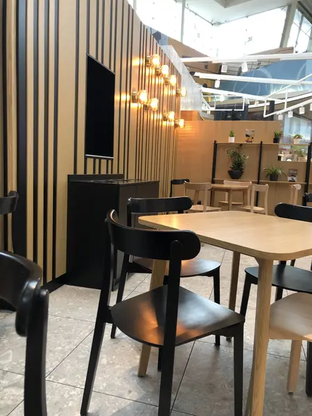 Wnętrze kawiarni w stylu japandi, minimalistycznym i nowoczesnym z drewnianymi detalami.
