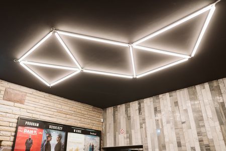 Wnętrze z minimalistycznym oświetleniem LED i nowoczesną kamienną ścianą w stylu współczesnym.