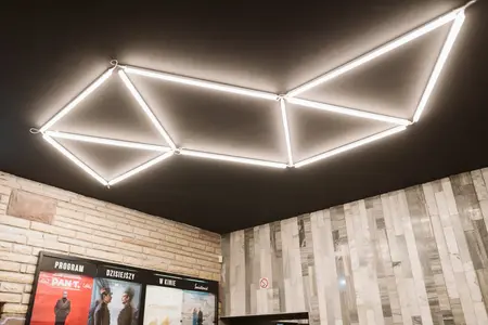 Wnętrze z minimalistycznym oświetleniem LED i nowoczesną kamienną ścianą w stylu współczesnym.