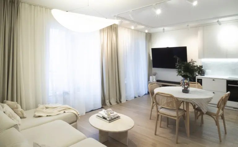 Wnętrze salonu z jasnymi zasłonami i drewnianym stołem, styl quiet luxury.
