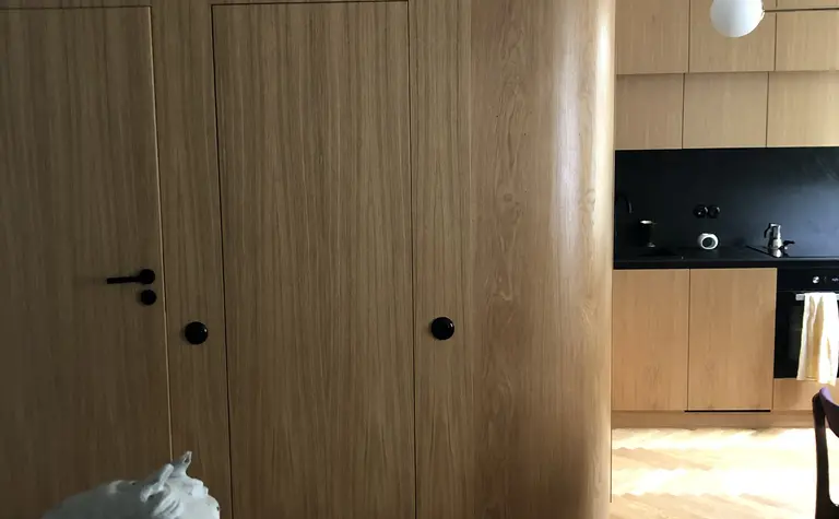 Wnętrze kuchni w stylu japandi z drewnianymi elementami i czarnymi akcentami.