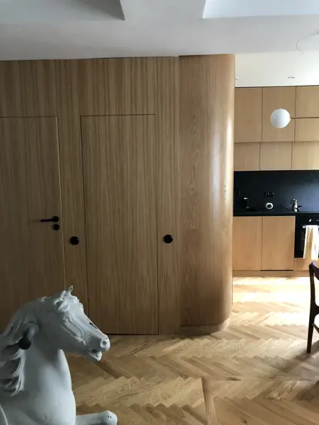 Wnętrze kuchni w stylu japandi z drewnianymi elementami i czarnymi akcentami.