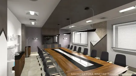 Wnętrze sali konferencyjnej z dużym stołem, nowoczesnymi krzesłami i oświetleniem.