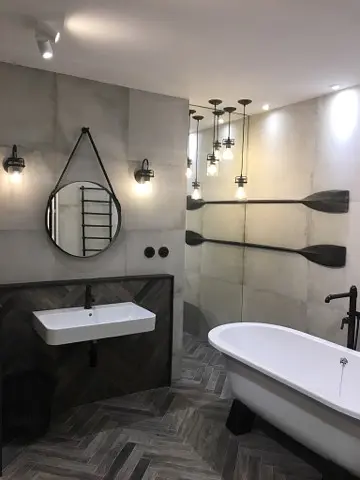 Nowoczesna łazienka glamour z białą wanną i szarymi ścianami.