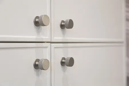 Nowoczesne meble kuchenne w białym kolorze z metalowymi uchwytami, styl skandynawski, tradycyjny, współczesny.