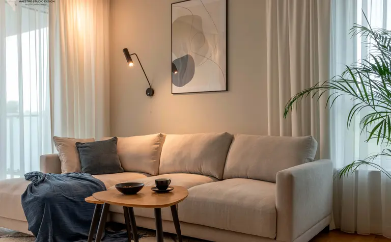 Wnętrze salonu w stylu boho z beżową sofą i rośliną