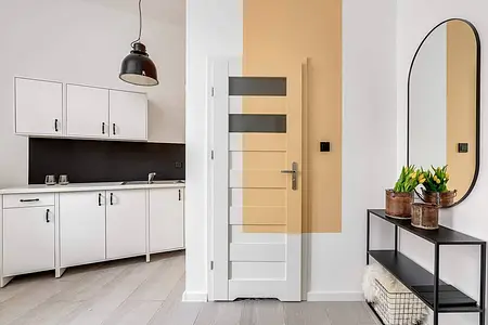Wnętrze kuchni z białymi szafkami i czarnym blatem, industrialny styl