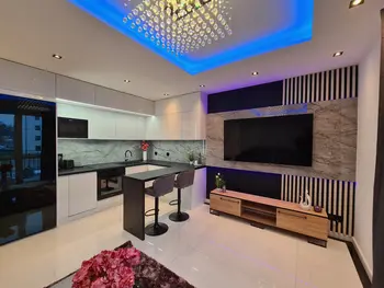Nowoczesna kuchnia z białymi meblami i czarnymi detalami, z eleganckim blatem.