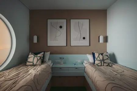 Wnętrze pokoju z dwoma łóżkami, minimalistycznymi obrazami oraz skandynawskim designem.