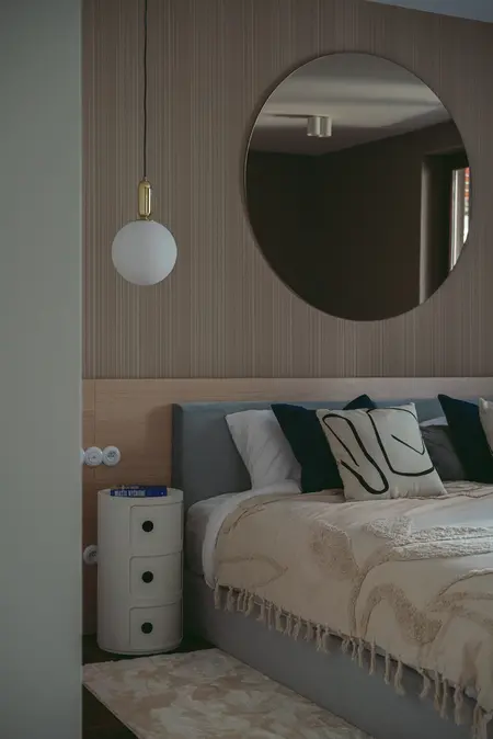 Sypialnia w stylu eklektycznym z nowoczesnym oświetleniem i minimalistycznym wystrojem.