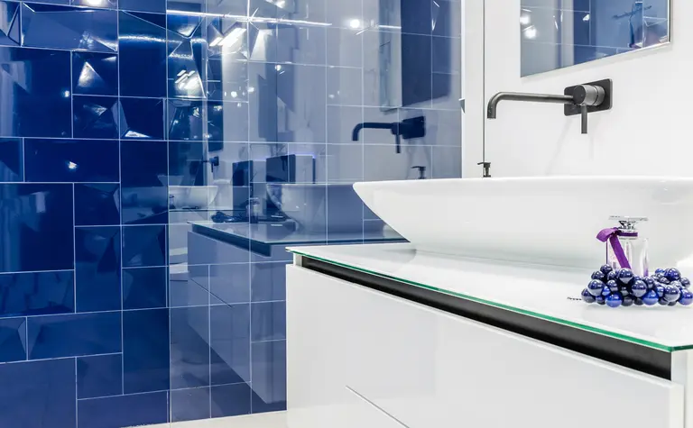 Nowoczesna łazienka z niebieskimi płytkami, białą umywalką i minimalistycznym designem