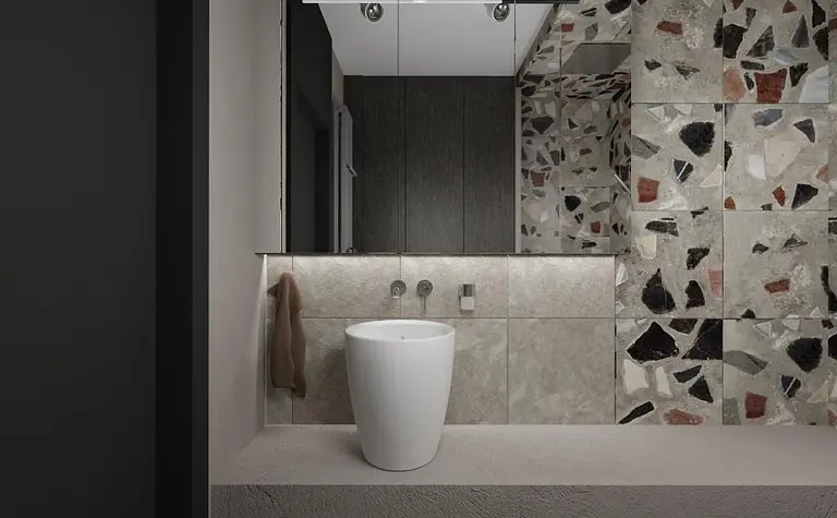 Wnętrze łazienki w stylu industrialnym z białym WC i mozaikowymi płytkami.