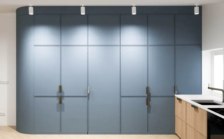 Kuchnia minimalistyczna z niebieskimi szafkami i białym blatem.