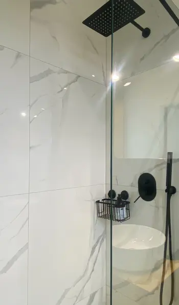Nowoczesna łazienka z minimalistycznym prysznicem, skandynawskimi akcentami i quiet luxury.