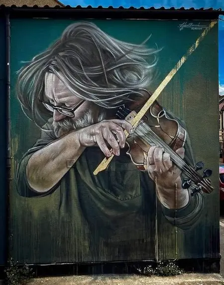 Mural artystyczny przedstawiający mężczyznę grającego na skrzypcach w stylu eklektycznym i nowoczesnym.
