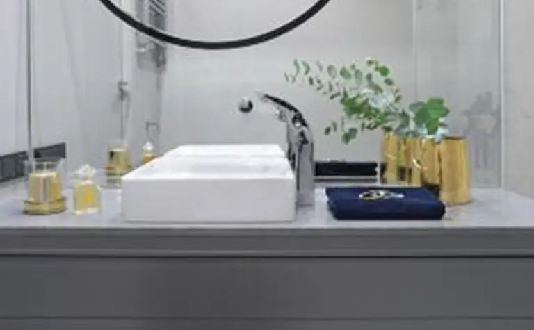 Nowoczesna łazienka z minimalistycznym designem, szarymi detalami i roślinnością.