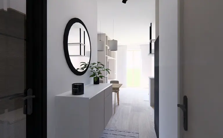 Przedpokój w stylu minimalistycznym z białymi meblami i czarnymi detalami.