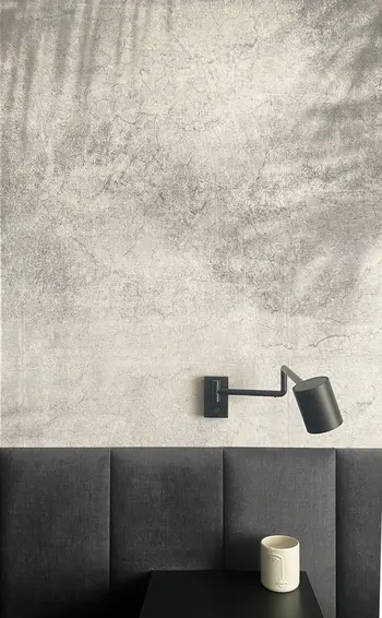 Minimalistyczne wnętrze z szarym tłem i czarną lampą w stylu quiet luxury i skandynawskim.