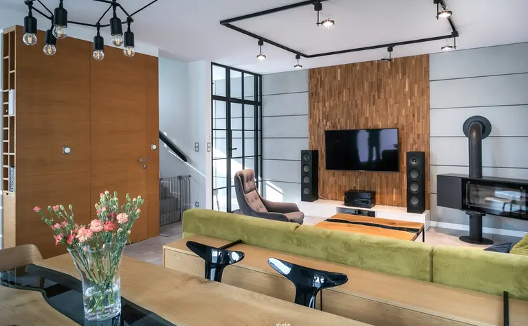 Wnętrze salonu w stylu industrialnym i minimalistycznym z drewnianymi elementami.