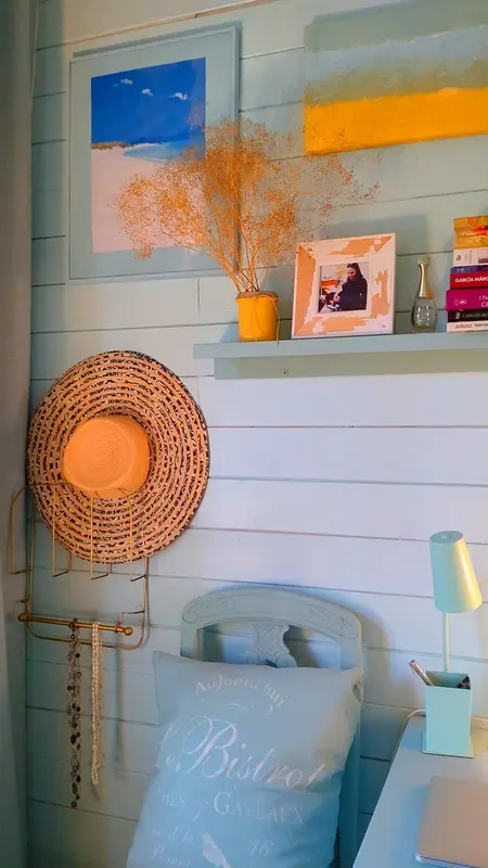 Wnętrze pokoju z boho i vintage dekoracjami, niebieskimi akcentami i roślinami.