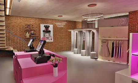Wnętrze sklepu odzieżowego w stylu nowoczesnym i quiet luxury z różowymi detalami.