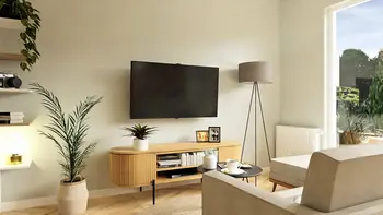 Wnętrze salonu z roślinami, boho i minimalistycznym designem, nowoczesne oświetlenie.