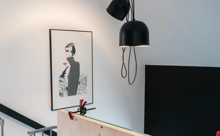Wnętrze z industrialnymi lampami i minimalistycznym panelem na ścianie, styl skandynawski.