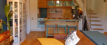 Kuchnia w stylu boho z drewnianymi meblami i niebieskimi detalami, industrialne akcenty