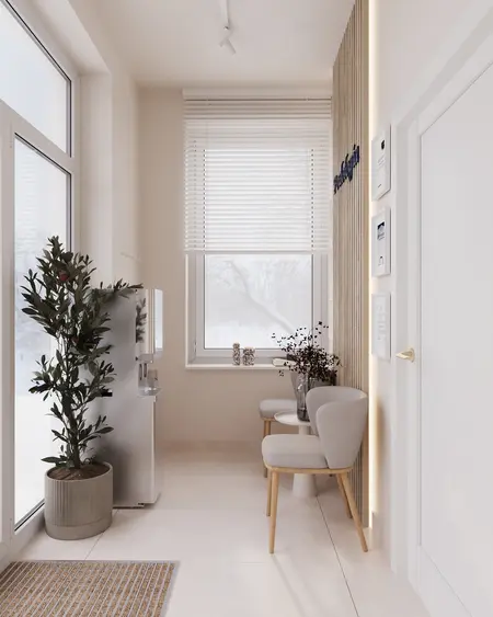 Przedpokój z minimalistycznym designem, rośliną i jasnymi meblami.