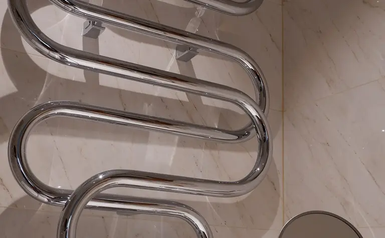 Designerska łazienka z chromowanym grzejnikiem i lustrem w tradycyjnym stylu.