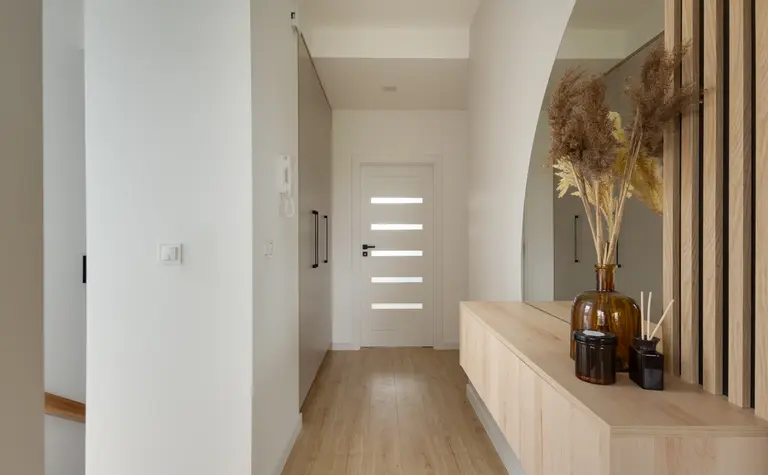 Przedpokój w stylu japandi z drewnianymi detalami i minimalistycznym wystrojem.
