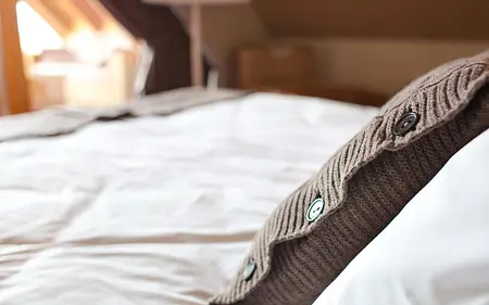 Sypialnia w stylu boho z brązową pościelą oraz eklektycznymi akcentami.