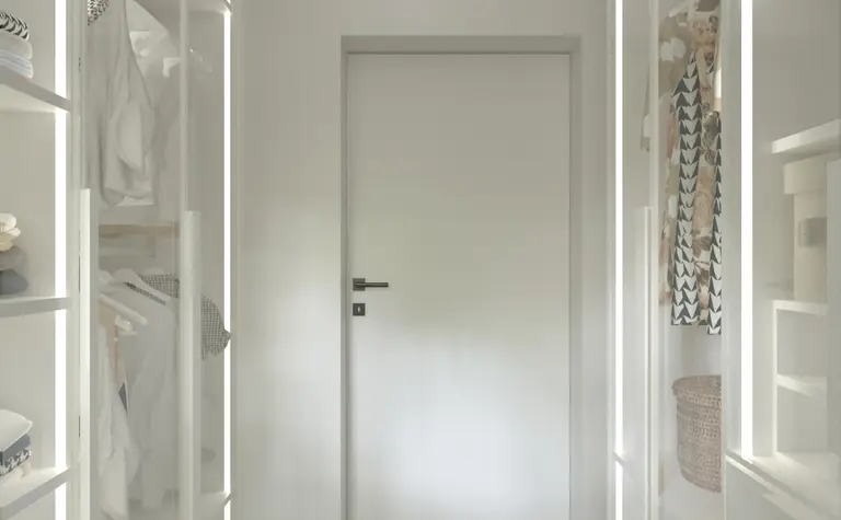 Garderoba minimalistyczna z białymi meblami i jasnym dywanem, idealna do przechowywania.
