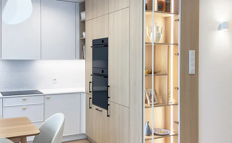 Kuchnia w stylu glamour, japandi i minimalistycznym z białymi meblami i drewnianymi detalami.
